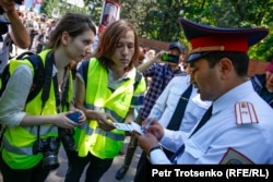 Шествие «Бессмертного полка» в Алматы. Полицейские проверяют документы у журналистов, 9 мая 2019 года.