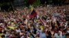 Anti-government protesters hold their hands up during the symbolic swearing-in of Juan Guaido. January 23.