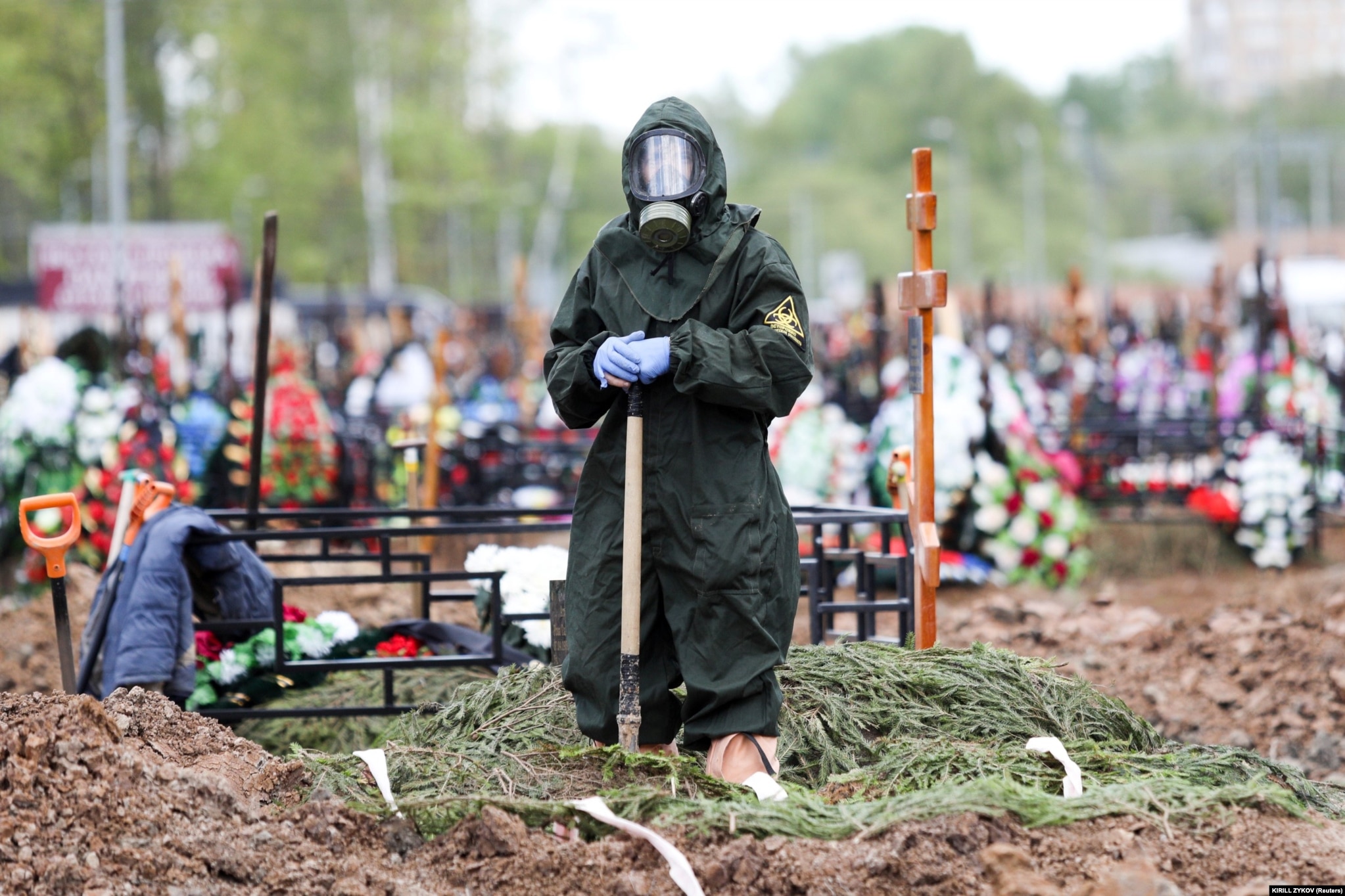 A gravedigger wearing a protective suit stands by a grave during the burial of a COVID-19 victim on the outskirts of Moscow on May 15.