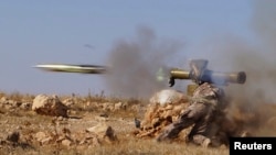 A rebel Free Syrian Army fighter fires an antitank missile in the eastern Hama region earlier this month.