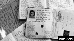 عکسی از گذرنامه آنه فرانک در کنار دفتر خاطرات او