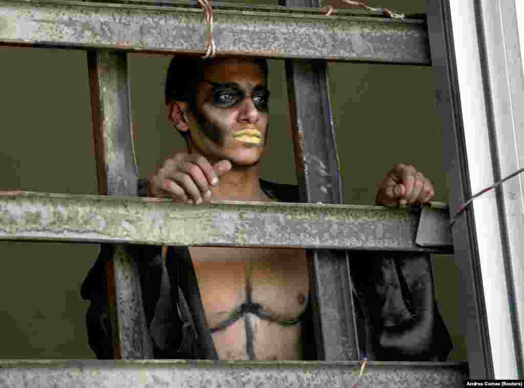 An Iraqi actor in make-up looks out a window before a performance in Baghdad of &quot;Obey The Devil,&quot; a modern intepretation of Shakespeare&#39;s &quot;Othello.&quot;