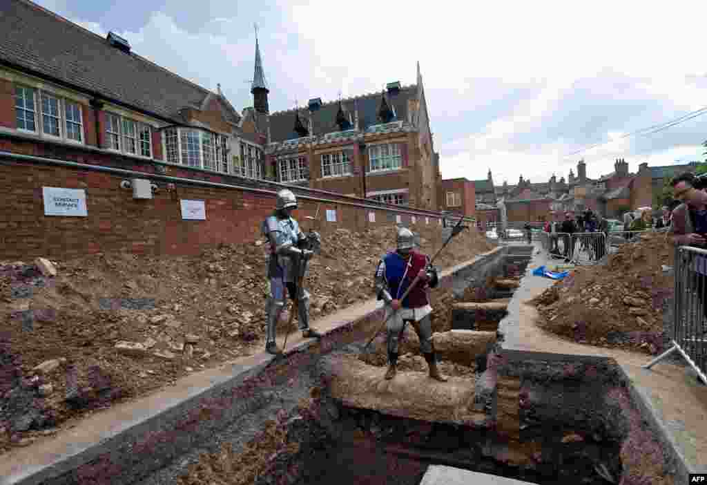 Men dressed as medieval knights pose for pictures at the excavation site. The remains of the king will later be buried at the cathedral in the city of Leicester, not far from where they were uncovered.