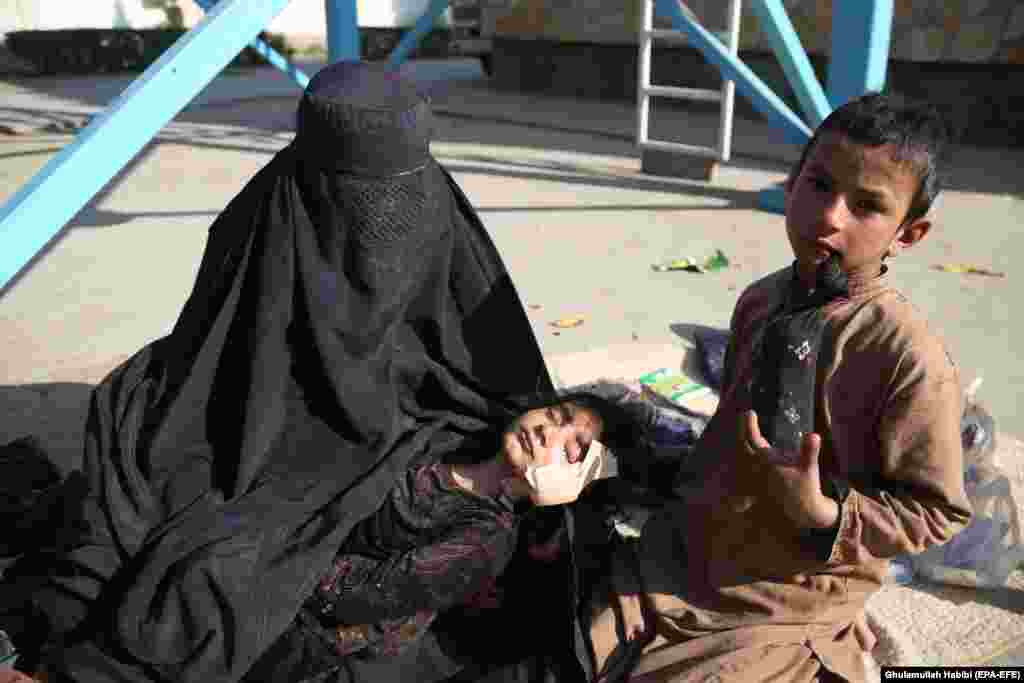 A mother holds her daughter who was injured in an air strike in Kunar Province as she receives medical treatment at a hospital in Jalalabad, Afghanistan. According to local officials, at least 20 Afghan civilians, including 12 children, were killed in an air strike targeting a Taliban commander. (epa-EFE/Ghulamullah Habibi)