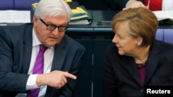 Germany -- Chancellor Angela Merkel (R) listens to Foreign Minister Frank-Walter Steinmeier during a session of the lower house of parliament, the Bundestag, in Berlin, March 20, 2014