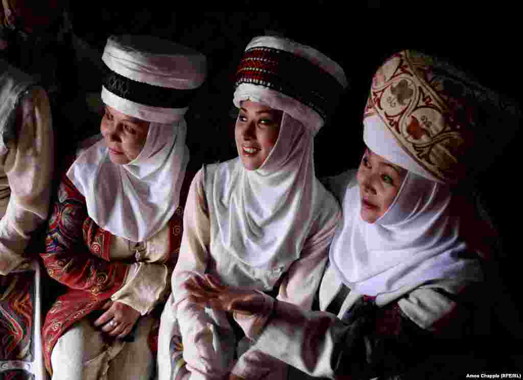 Three women from the Bishkek Drama Theatre wait out a rainstorm inside a yurt, after their performance was postponed.&nbsp;
