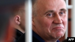 Mikalay Statkevich sits in the defendant's cage before the start of his trial in Minsk in May.