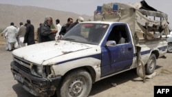 Police examine a damaged police van following a bomb attack in Quetta.