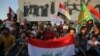 Iraqis holding national flags demonstrate against unemployment in the capital Baghdad's Tahrir Squareon July 14, 2018. Two demonstrators were killed in southern Iraq, officials said, as protests against unemployment spread today from the port city of Basr