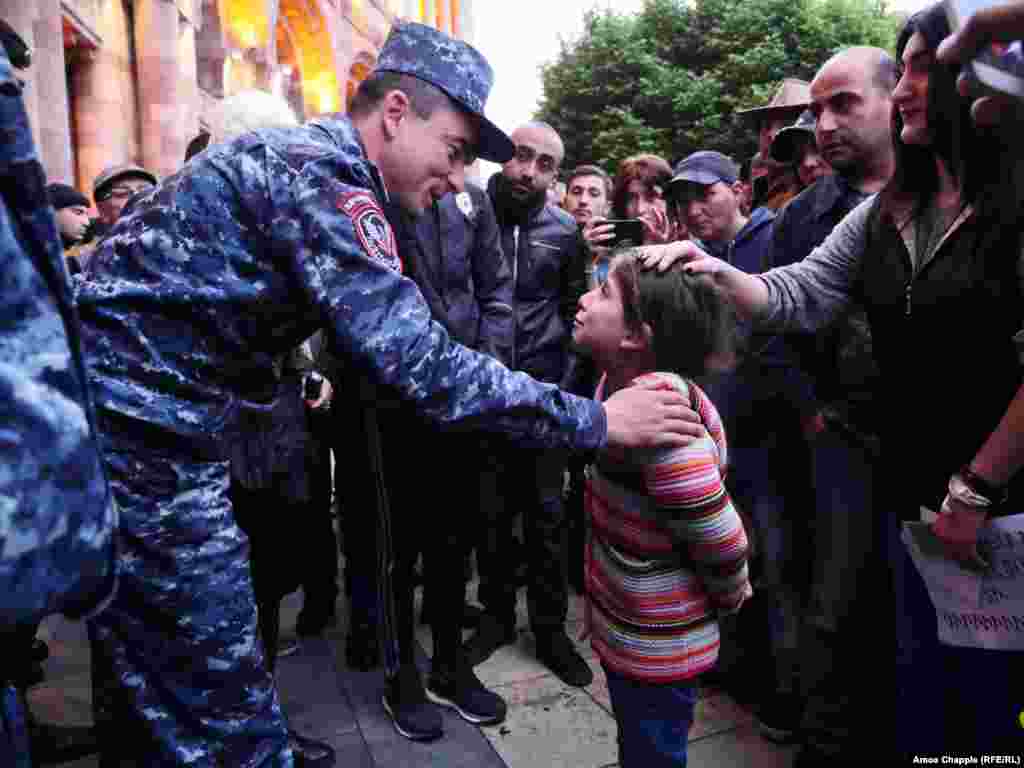 Thousands took to the streets of the Armenian capital, Yerevan, on April 20 for an eighth-straight day to protest the election of former President Serzh Sarkisian as prime minister. Here, 6-year-old Lucine Burtoyan said to a police officer guarding the government building: &quot;Come with us. Why are you with [Sarkisian]? Why aren&rsquo;t you with your people?&quot; (RFE/RL/Amos Chapple)