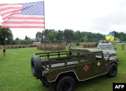 Український та американський прапор на автомобілях військових під час церемонії відкриття навчань на Яворівському полігоні