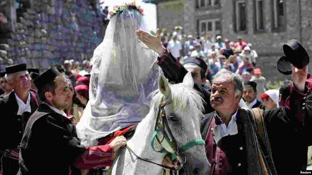 Macedonian bride-to-be Danica Torteska is led on horseback to her husband by her father-in-law and marriage witnesses during a wedding ceremony in the village of Galicnik on July 15. (REUTERS/Ognen Teofilovski)