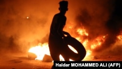 A demonstrator burns tires during protests in the southern Iraqi city of Basra on July 12.