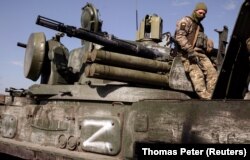 Një ushtar ukrainas qëndron në një makinë ushtarake ruse që ka të vizuar simbolin 'Z'. Harkiv, 29 mars 2022.