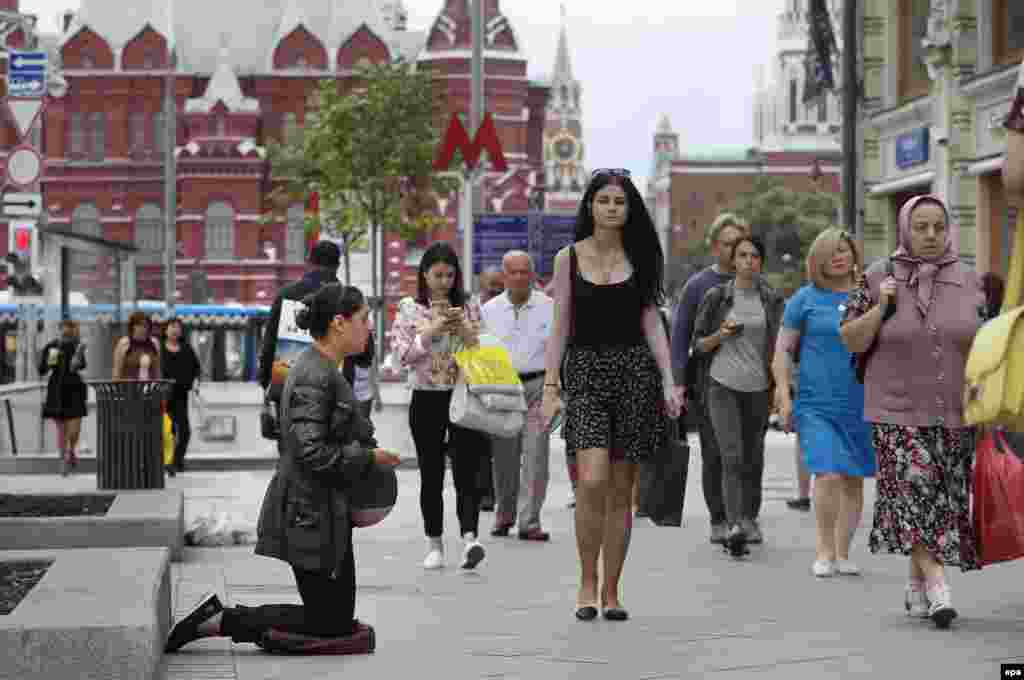 Një grua shtatzënë duke u lutur në rrugën e rinovuar &quot;Tverskayaut&quot; në Moskë.