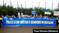 Транспарант із написом «НАТО, зупини геноцид, здійснюваний Росією в Україні» на акції проти російської збройної агресії біля штаб-квартири НАТО. Брюссель, Бельгія, 13 жовтня 2022 року