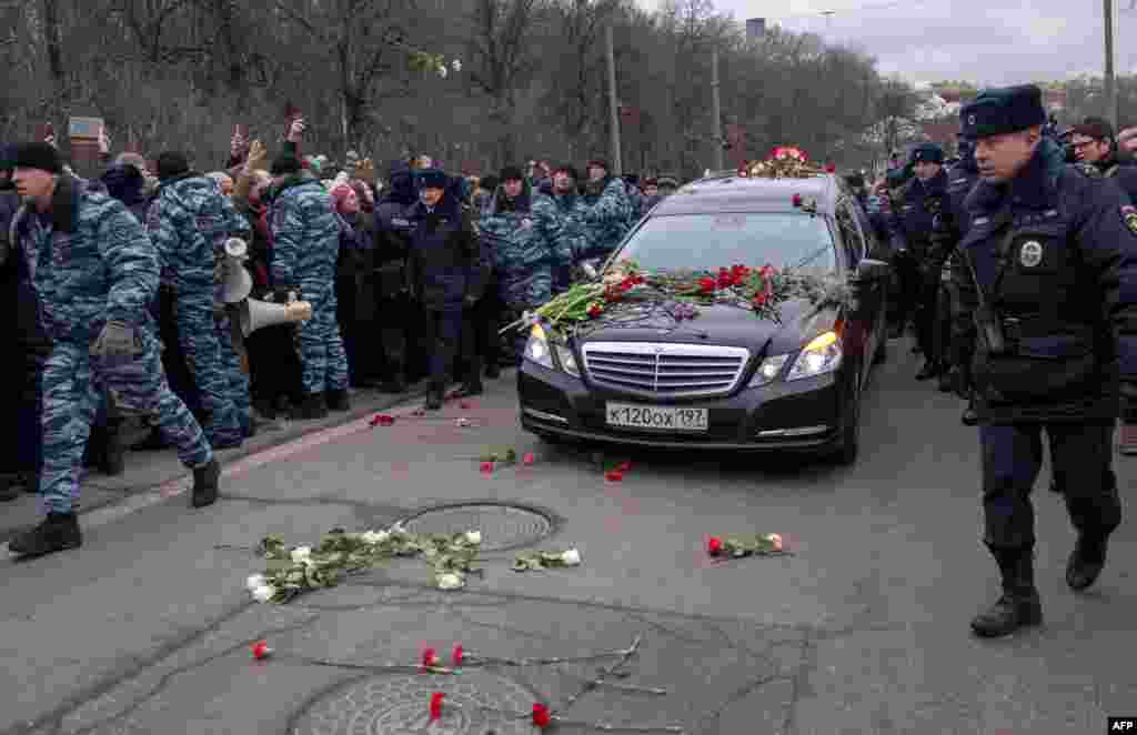 People throw flowers ahead of a hearse transporting Nemtsov&#39;s coffin to the cemetery.