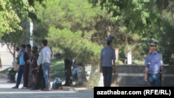 Türkmenistanyň köçeleriniň birinde duran polisiýa işgärleri we ýaşaýjylar (Arhiwden alnan illýustrasiýa suraty)