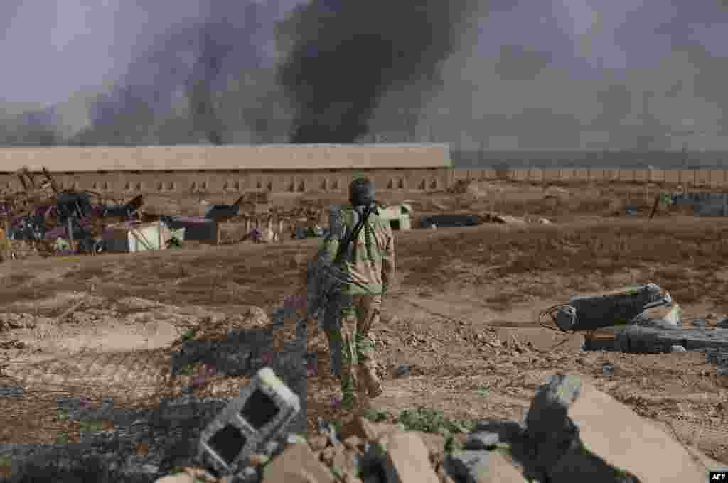 An Iraqi Shi&#39;ite fighter fighting alongside Iraqi forces walks in the town of Baiji north of Tikrit, during fighting against the Islamic State (IS) jihadist group to retake the strategic northern Iraqi town on October 15. (AFP/Muhammad Sawaf)