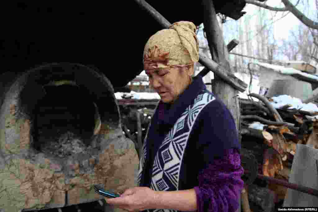 Казахская женщина готовит традиционный узбекский тандырный хлеб.