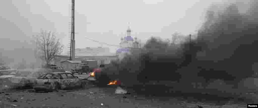 Cars burn on a street in Mariupol after the east Ukrainian city was hit by shelling on January 24.
