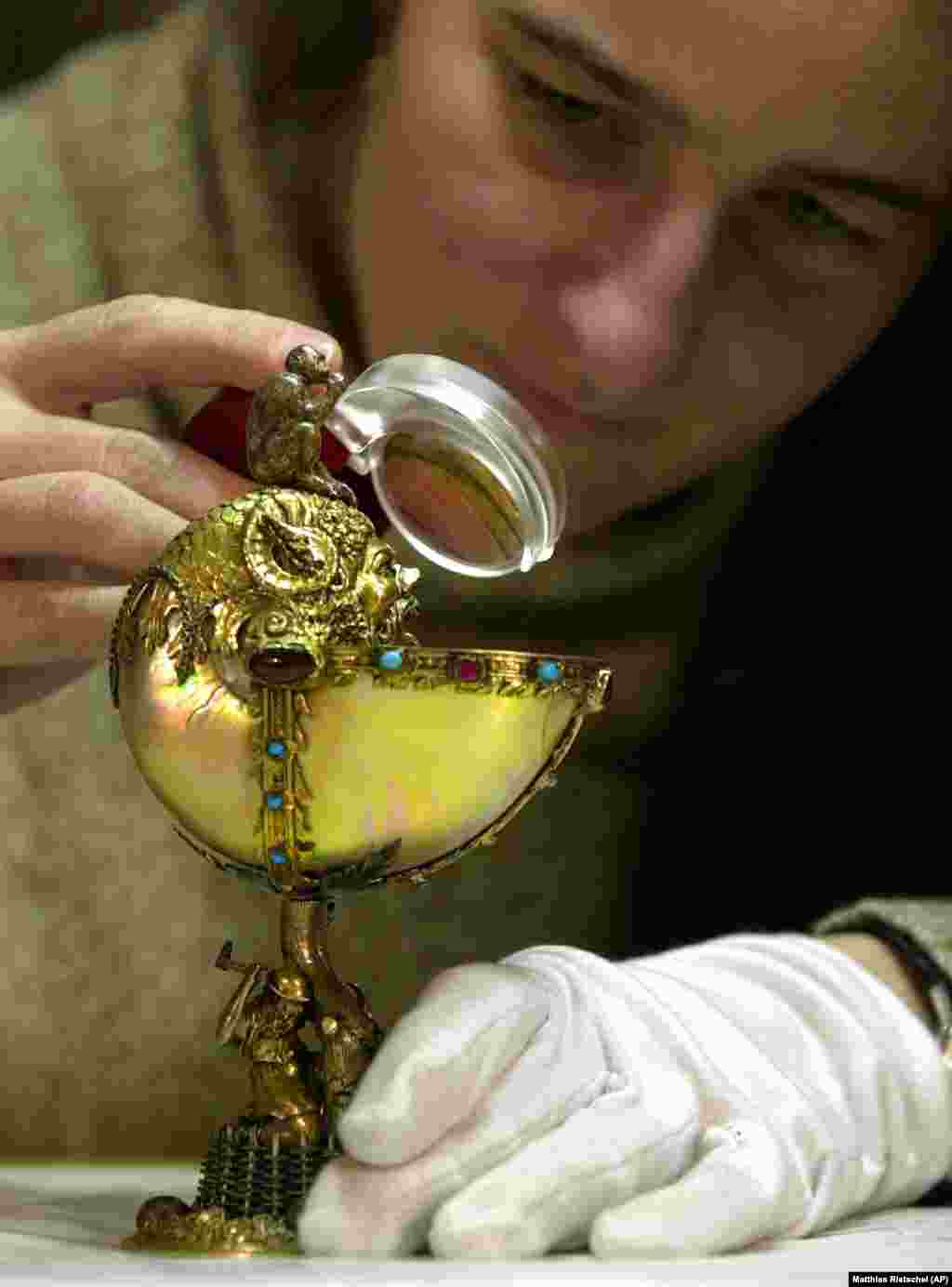 A restorer inspects a &quot;Nautilus Cup&quot; dating from 1570. It&#39;s made of ivory, rubies, silver, and gold.