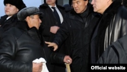 Президент Нурсултан Назарбаев смотрит на пожилого мужчину, в руках которого белый платок. Жанаозен, Мангистауская область, 22 декабря 2011 года. Фото с сайта akorda.kz