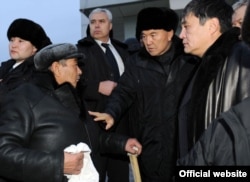 Қолына ақ орамал ұстаған жергілікті тұрғын президент Нұрсұлтан Назарбаевқа (оң жақтан екінші) арызын айтып тұр. Жаңаөзен, 22 желтоқсан, 2011 жыл