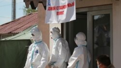 Специалисты в защитных костюмах у входа в дневной стационар в Бишкеке. 6 июля 2020 года.