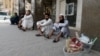 FILE: Pakistani workers sit along a street in the Saudi capital Riyadh after losing their jobs.