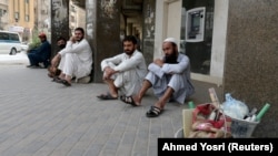 FILE: Pakistani workers sit along a street in the Saudi capital Riyadh after losing their jobs.