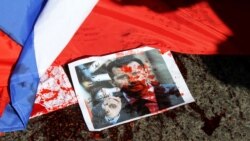 A picture of Syrian President Bashar al-Assad sprayed with red paint lies on the ground next to a Russian flag about to be set on fire by protesters during a demonstration outside the Russian Embassy in Beirut on February 5.