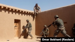 FILE: A U.S. Marine watches Afghan National Army (ANA) soldiers during a training in Helmand province, in July 2017.