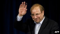 Mohammad Baqer Qalibaf waves after registering his candidacy for the June presidential election.