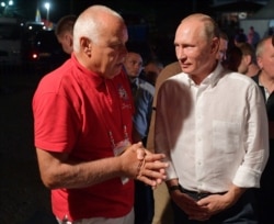 Russian TV host Dmitry Kiselyov (left) with President Vladimir Putin (file photo)