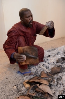 Bir adam Ahmed Baba merkezinde ýanan gadymy golýazmalary saýlaýar. Mali. 29-njy ýanwar, 2013 ý.