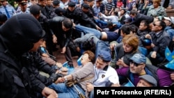 Полицейские задерживают людей на площади в центре Алматы. 9 июня 2019 года.