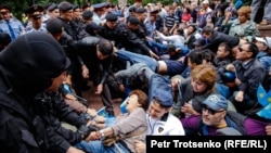 Полицейские задерживают людей на площади в центре Алматы в день досрочных президентских выборов. 9 июня 2019 года.