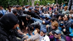 Полиция қызметкерлері кезектен тыс президент сайлауы күні Алматының орталығындағы саябаққа жиналған азаматтарды күштеп әкетіп жатыр. 9 маусым 2019 жыл.