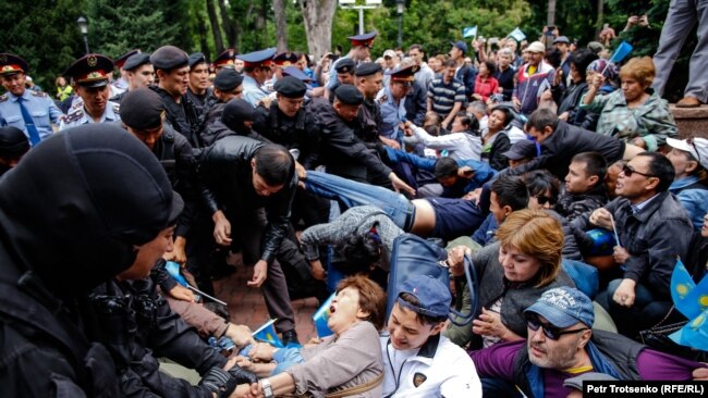 Полицейские задерживают людей на площади в центре Алматы в день президентских выборов. 9 июня 2019 года