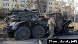 Украинский солдат проходит мимо уничтоженной российской установки "Град" в Харькове. Март 2022 года 