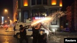 Полицейские применяют слезоточивый газ в ходе антиправительственных демонстраций в Стамбуле, 16 июня 2013 года. 