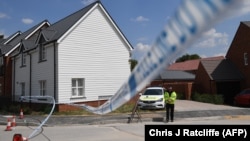 A police officer guards a cordon at a residential address in Amesbury, southern England, where Dawn Sturgess and Charlie Rowley were found unconscious in June. 