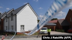 A police officer guards a cordon at a residential address in Amesbury, southern England, where police reported a man and woman were found unconscious.