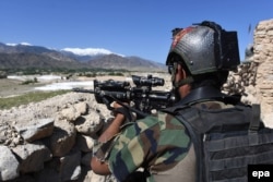 An Afghan soldier stands guard near the site where the U.S. Air Force dropped a GBU-43 Massive Ordnance Air Blast (MOAB) on an Islamic State (IS) militant cave complex in the Asad Khel area of Achin district, Nangarhar Province, in April.