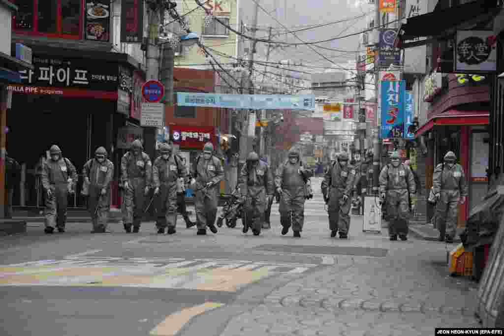 South Korean soldiers spray disinfectant in the street as a precaution against the spread of the novel coronavirus in Seoul on March 4. (epa-EFE/Jeon Heon-kyun)