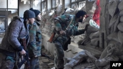 Syrian pro-government forces patrol an abandoned building in a newly retaken area of Aleppo's Old City on December 8.