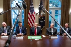 ABŞ-yň prezidenti Donald Tramp (ortada) žurnalistleriň öňünde çykyş edýär.