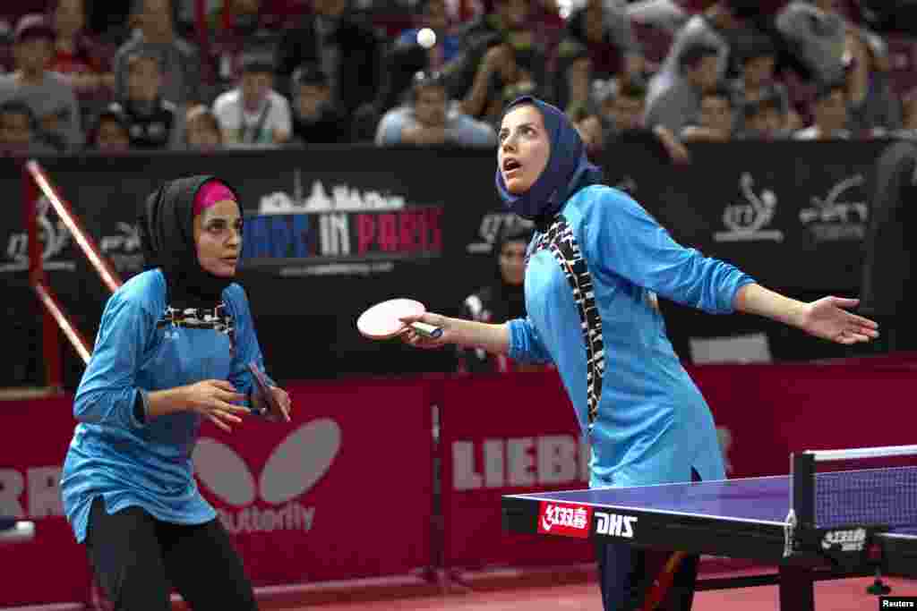 Iran's Mahjobeh Omrani (right) and Neda Shahsavari serve to Prachi Jha and Erica Wu of the United States during the women's double qualifying round at the World Team Table Tennis Championships in Paris. (Reuters/Charles Platiau)