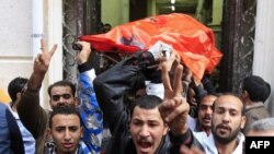 Egyptians transport the body of a Christian worshipper from the church to an ambulance following an overnight car-bomb attack in Alexandria.